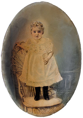 Apparently someone thought this little girl's hair wasn't light enough in the photo so they tried to improve it with white paint. PERMANENT paint Carol archivally repaired the damage to the photo and repainted the hair so that it seems the damage never happened. Note recovered detail in dress, bird's eye lace, etc. It took many hours of loving attention to detail. 